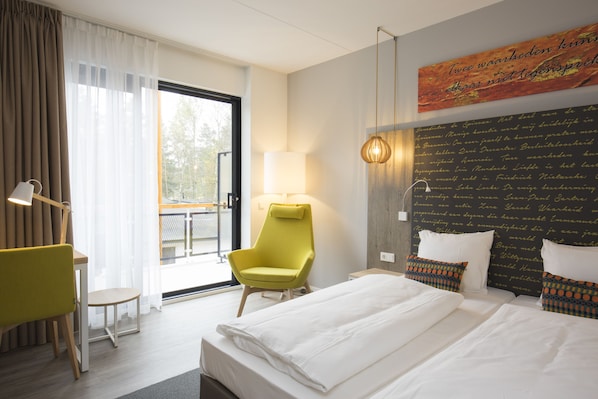 A hotel room with a bed, a chair, a table, a lamp, and a view of the outdoors. - Landgoed ISVW (Leusden-Centrum)