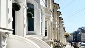 A row of white buildings with classic architecture, including ornate details and a uniform facade. - Seafield Seafront Apartments (Hove)
