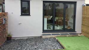 A modern house with a tiled roof, a sliding glass door, and a small window. - Luxury Victorian Garden Apartment (Bristol)