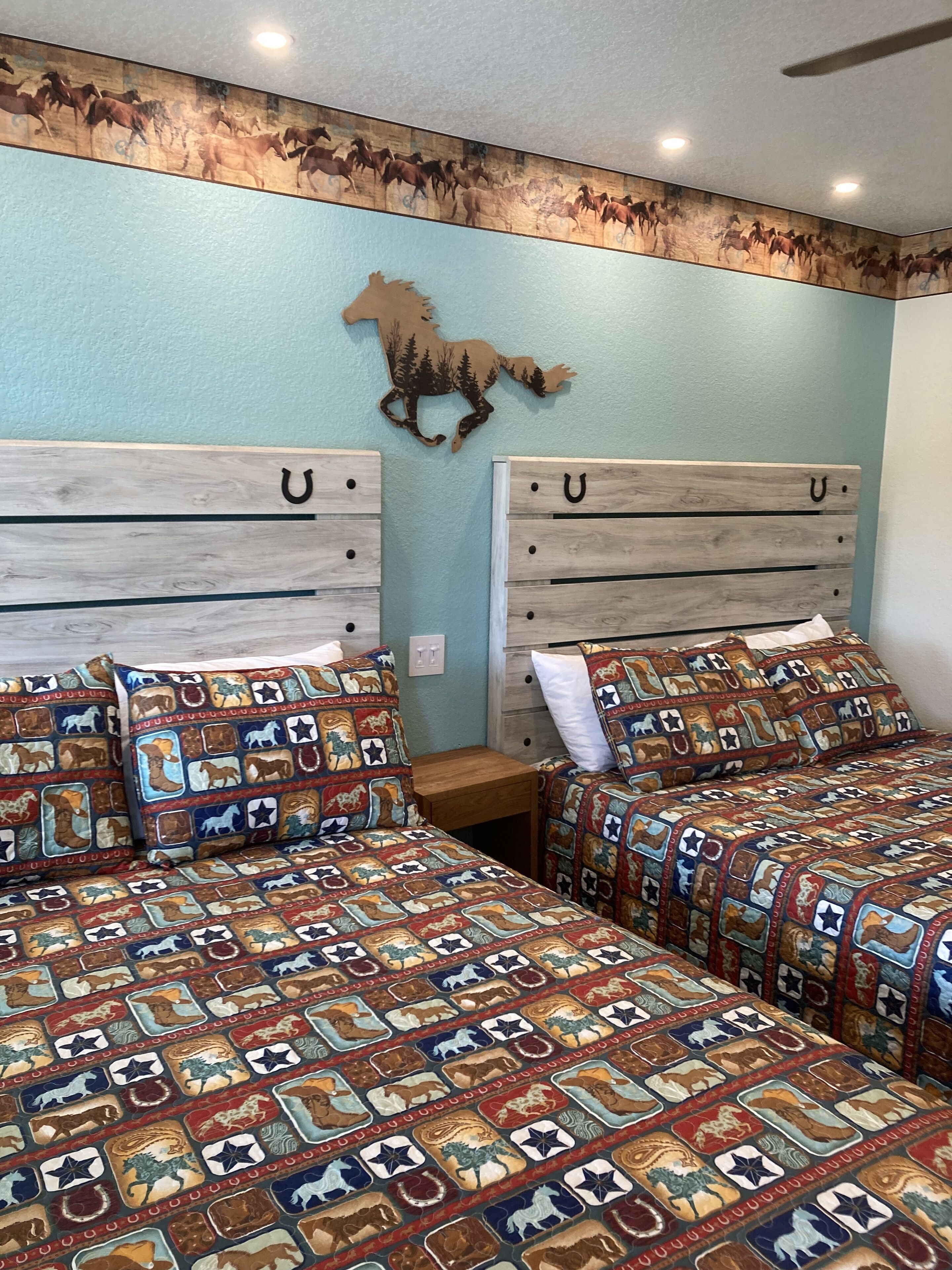 A bedroom with two beds, each with a unique headboard design and patterned bedding.