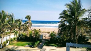 A beachfront property with a view of the ocean, palm trees, and a pathway leading to the beach. - Hotel Quinta Diamante - Barra vieja  (Acapulco)