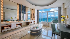 A modern bathroom with a large mirror, dual sinks, a bathtub, and a view of the ocean. - Atlantis Sanya (Sanya)