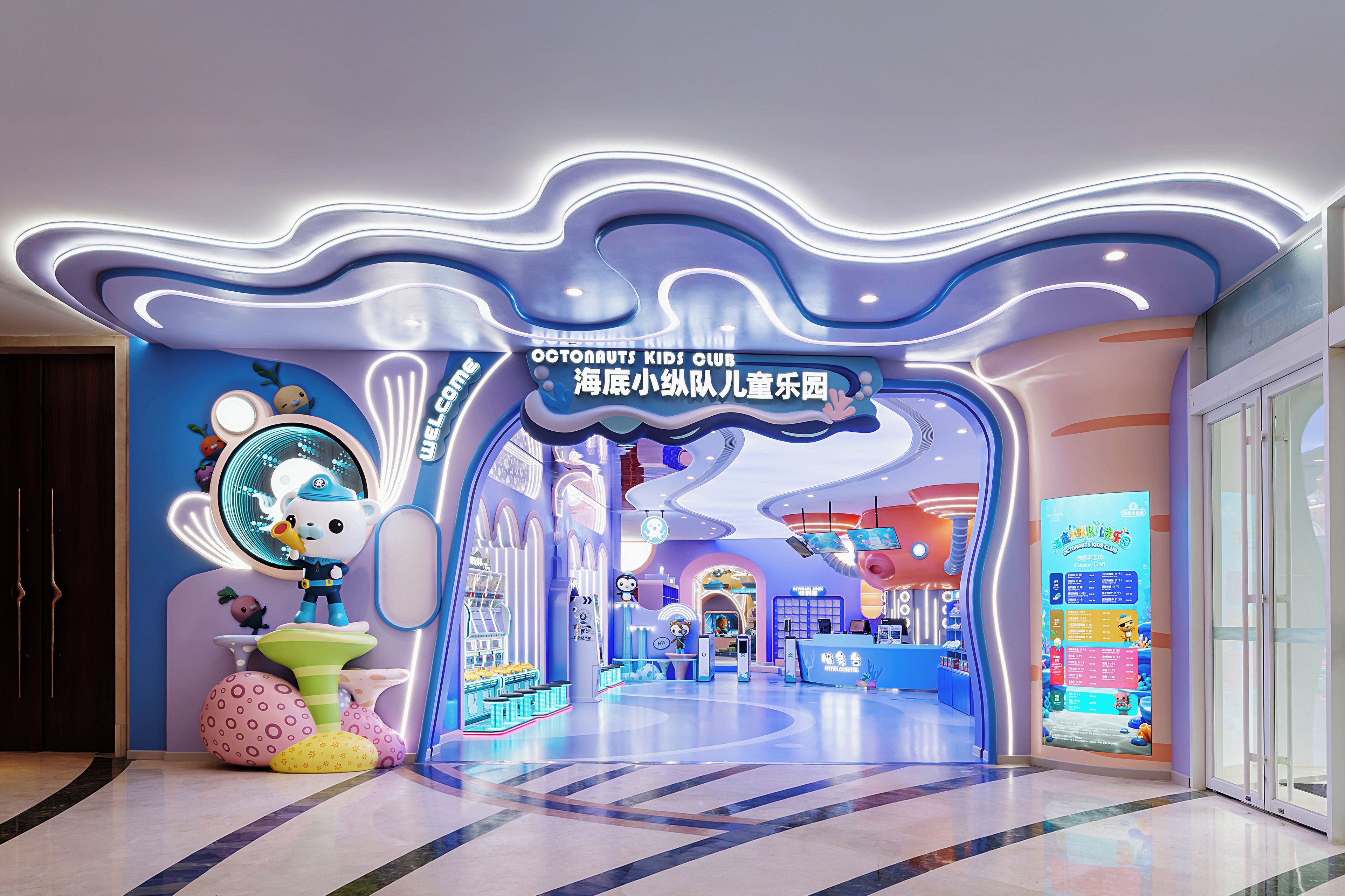 A children's play area with a colorful, wave-like ceiling design and a sign for 'Octonauts Kids Club'.