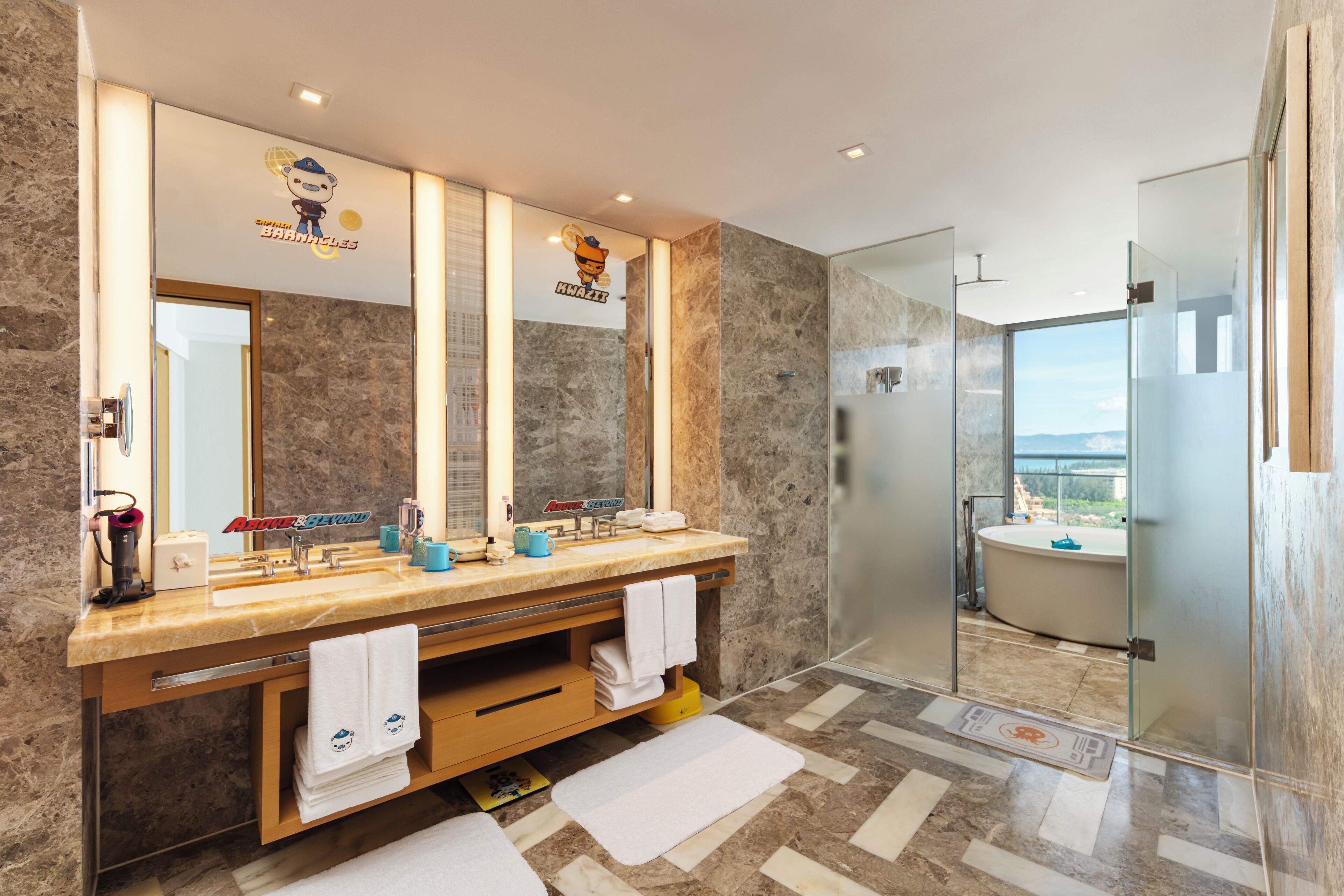 A modern bathroom with a double sink, large mirror, and a glass-enclosed shower.