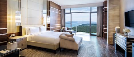 Una habitación de hotel moderna con una cama grande, un área de descanso y vistas a las montañas.
