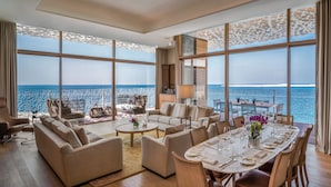 A spacious living room with a large dining area, comfortable seating, and a view of the ocean. - Bvlgari Resort Dubai (Dubai)