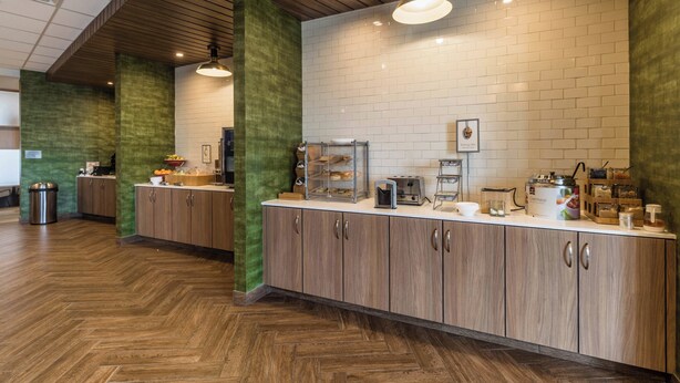 A modern kitchen with wooden cabinets, a white countertop, and a herringbone floor pattern. - Fairfield Inn & Suites by Marriott Brownsville North (Brownsville)