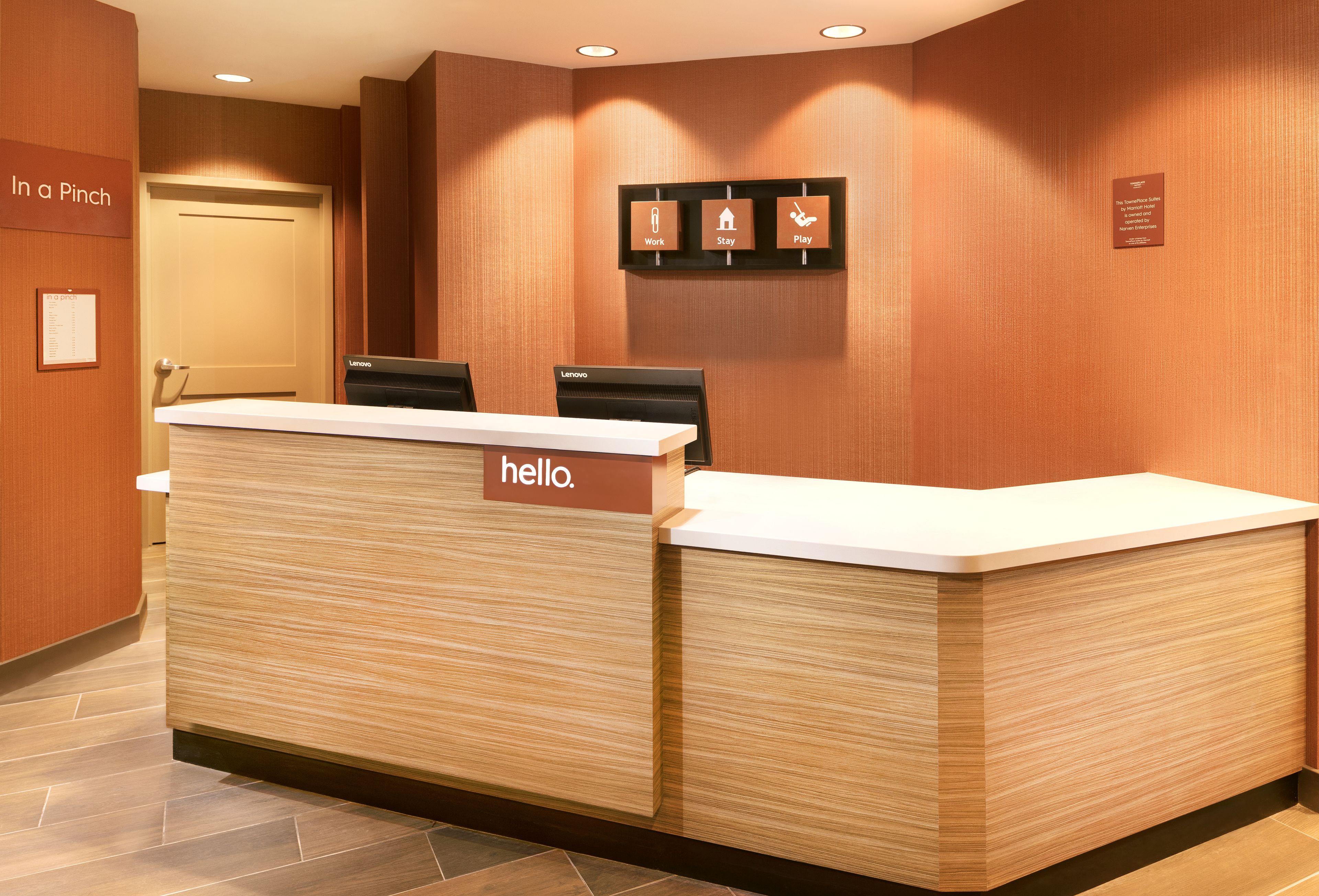 Una recepción con un letrero que dice 'hello', un letrero que dice 'Work' y un letrero que dice 'Stay' en la pared.
