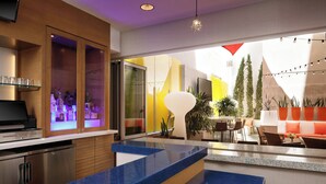 Une cuisine moderne avec un plan de travail bleu, un four encastré et un coin bar doté d’étagères en verre.