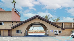 A building with a large arched entrance, a sign reading "HYLAND INN", and a parking lot in front.