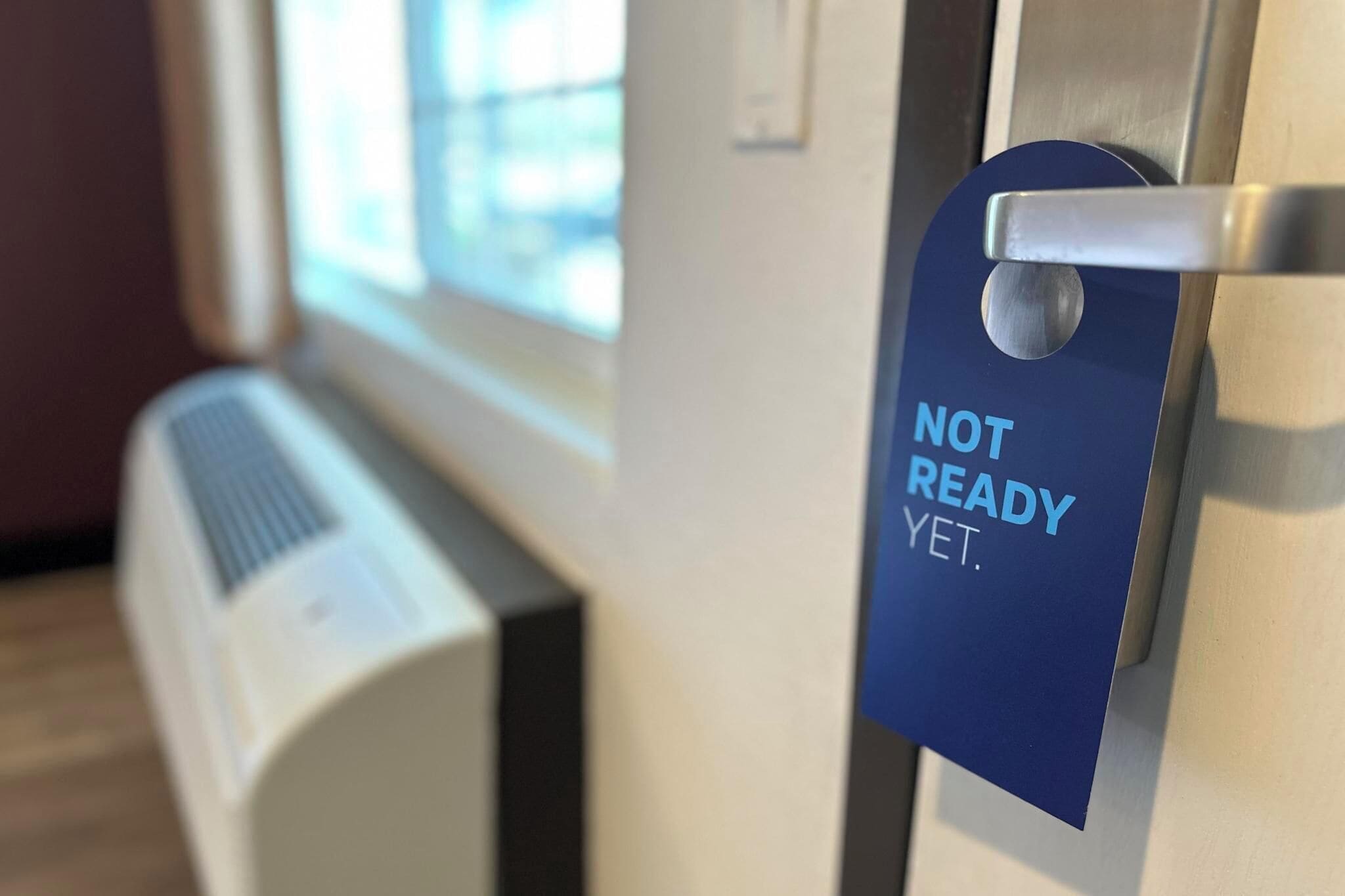 A door with a 'NOT READY YET' sign.