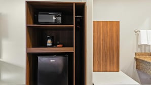 A compact kitchenette with a microwave, coffee maker, and refrigerator.