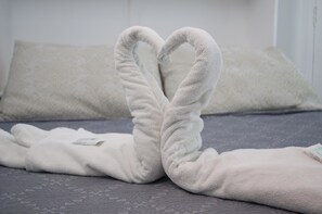 A bed with a heart-shaped towel arrangement. - Pousada Recanto Rubaiyat (Ipojuca)