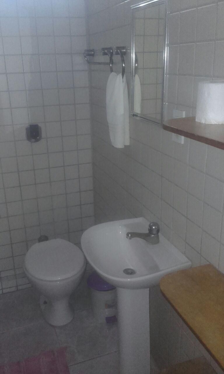 Un baño con inodoro, lavamanos y espejo.