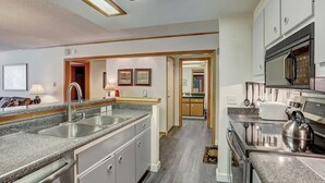 Una cocina moderna con encimeras de granito, electrodomésticos de acero inoxidable y armarios de madera.
