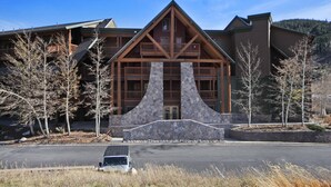 A lodge with a prominent stone facade, wooden balconies, and a clear sky. - 2609 Tenderfoot Lodge (Keystone)