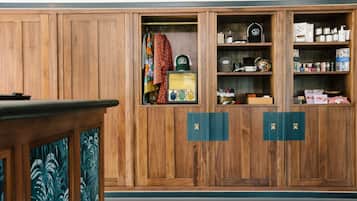 Un meuble en bois doté de plusieurs compartiments, dont certains contiennent des articles de toilette et d’autres des vêtements pliés.
