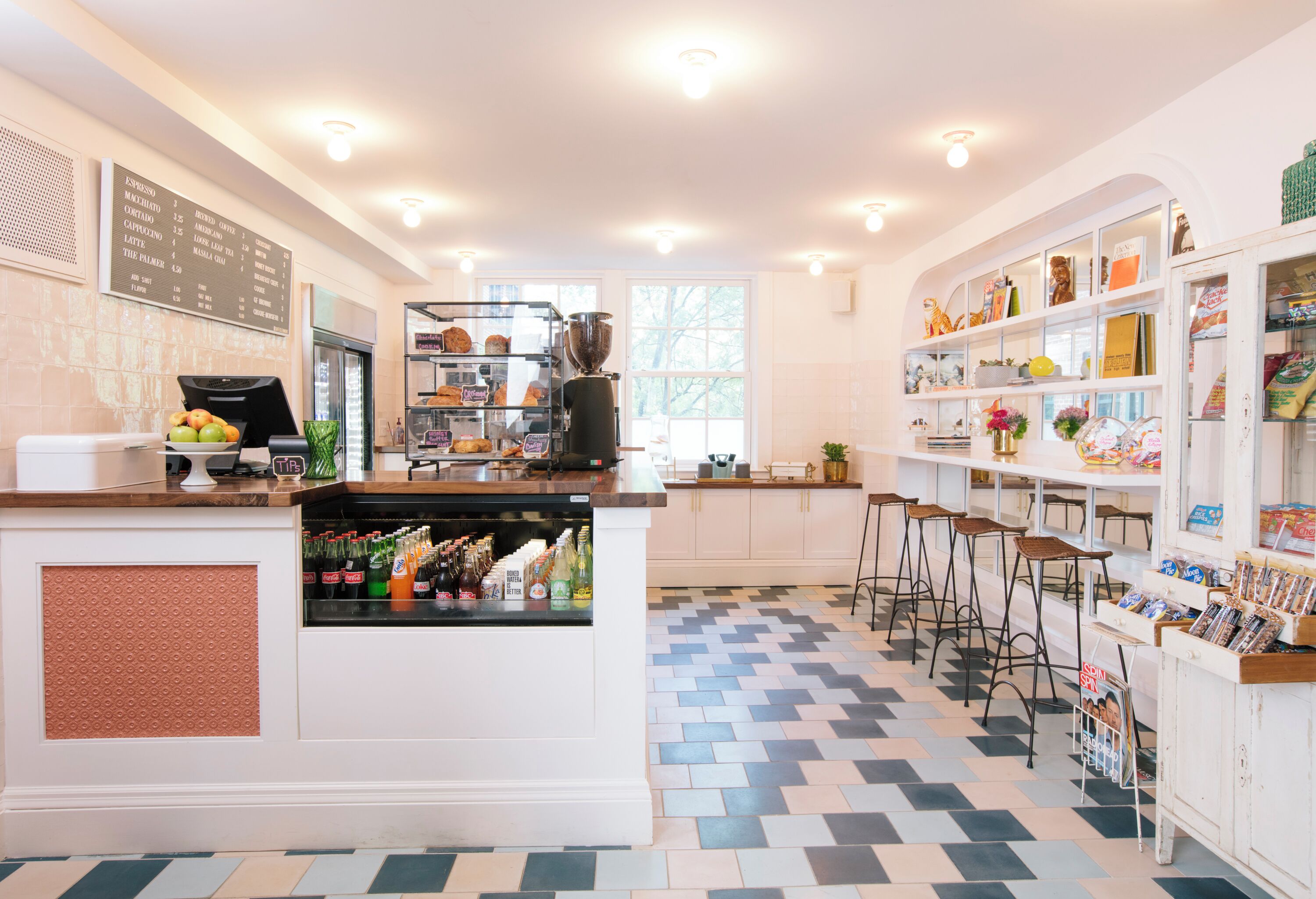 A modern kitchen with a central island, bar area, and a seating section with stools.