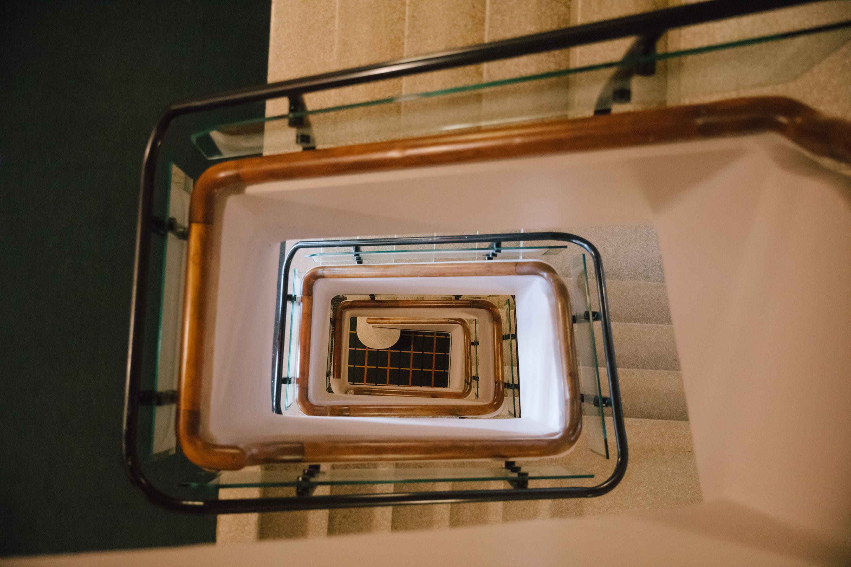 A spiral staircase with glass railings and wooden steps.