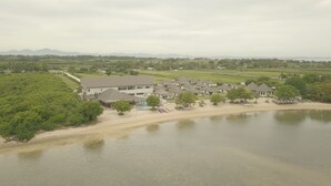 Een resort met meerdere gebouwen, een zwembad en een strandgedeelte.