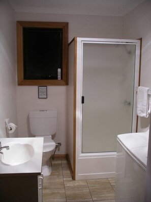 A bathroom with a toilet, sink, and shower. - Sunset Holiday Villas (Arthur River)
