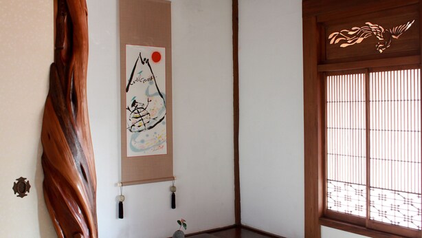 A traditional Japanese room with tatami flooring, a shoji screen, and a hanging artwork. - Guest House Kamejikan (Kamakura)