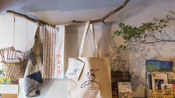 A display of bags and promotional materials, including a tote bag with a bird illustration and text, hanging from a branch.