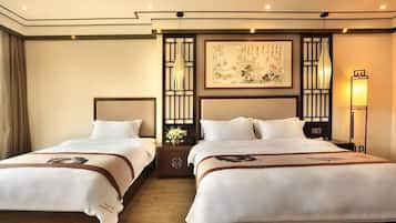 Habitación de hotel con dos camas, una obra de arte grande enmarcada en la pared y una lámpara de estilo tradicional.