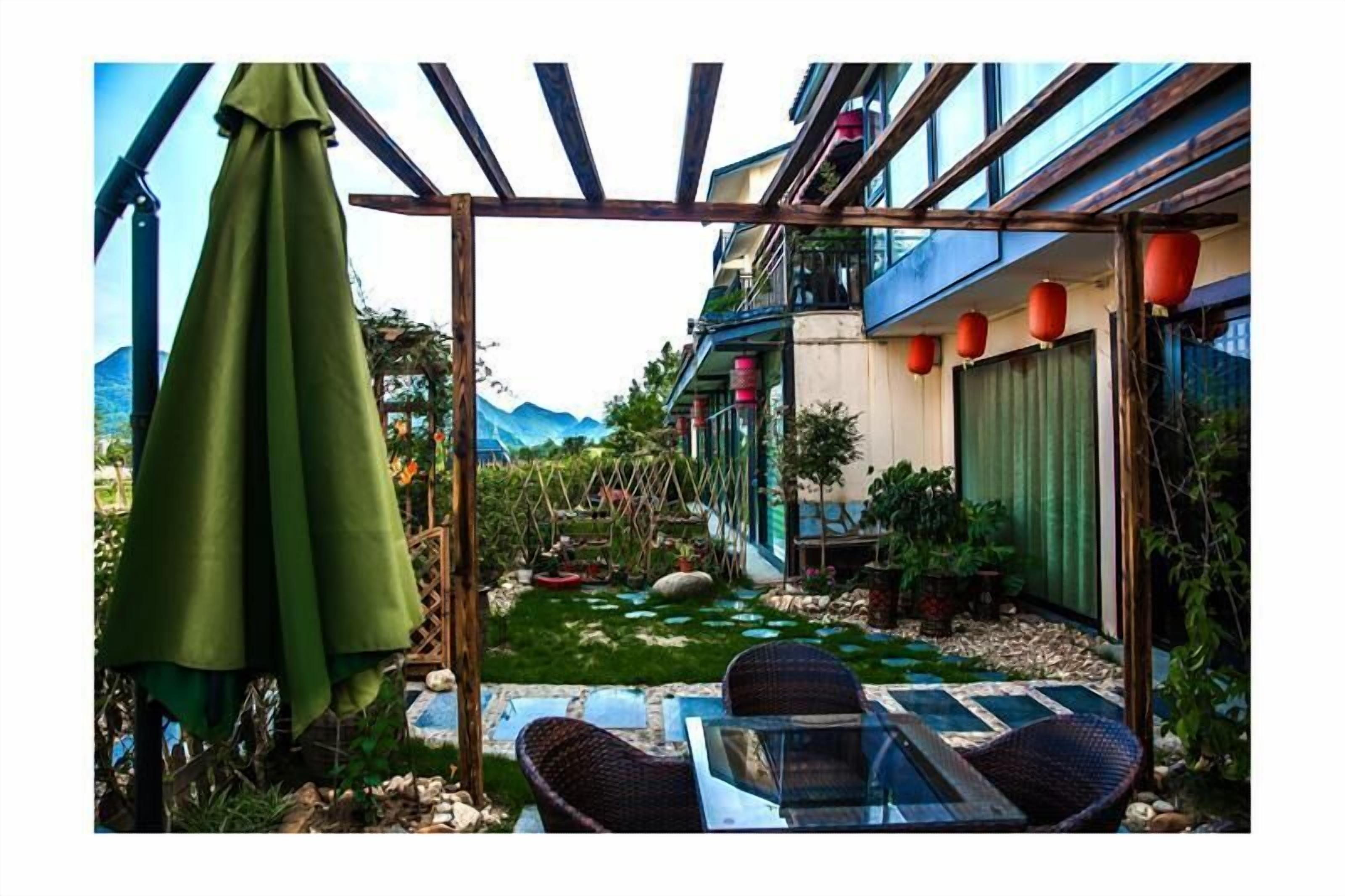 A courtyard with a pergola, outdoor seating, and a small garden area.