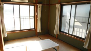 A traditional Japanese room with tatami flooring, a low wooden table, and sliding doors.