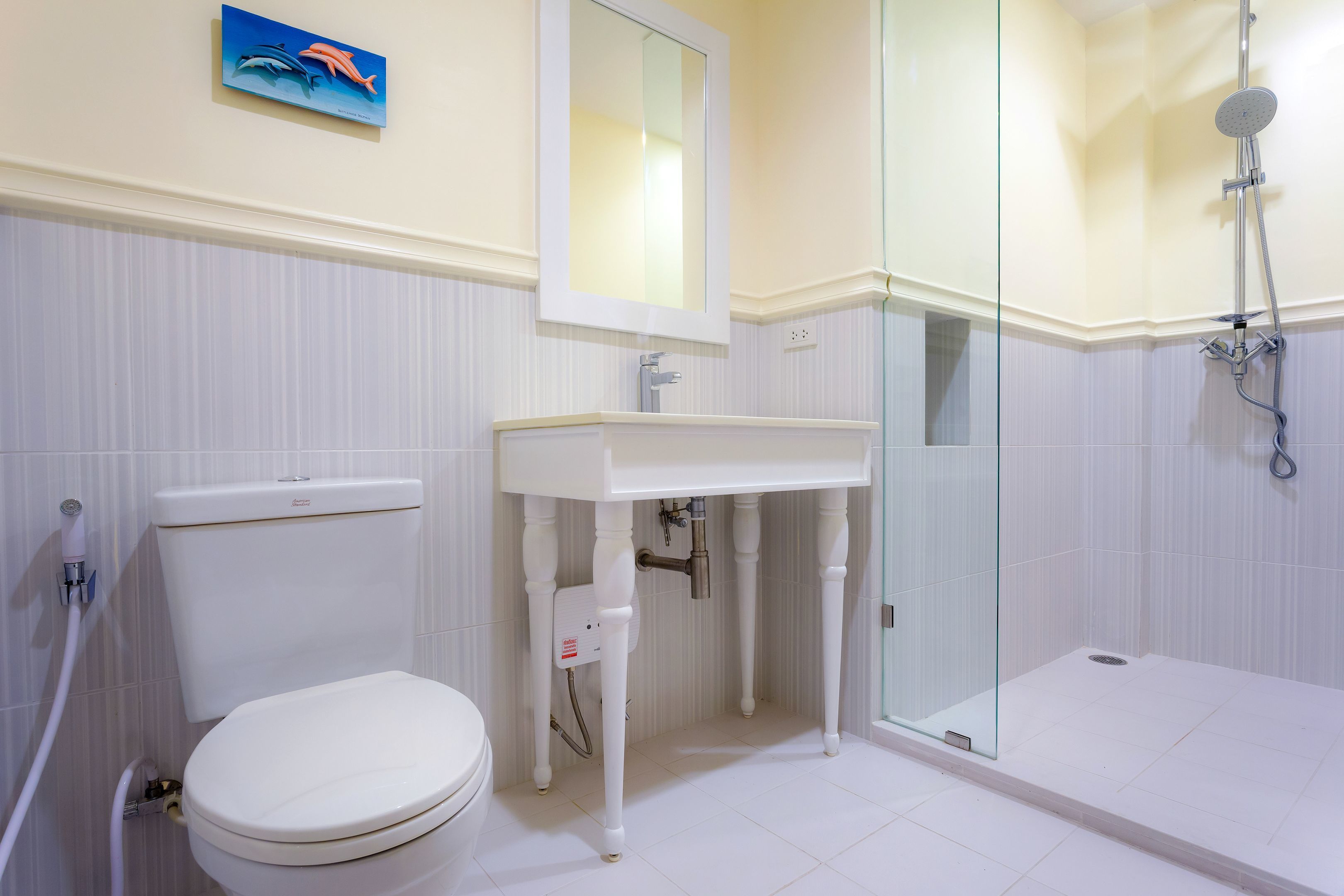 A bathroom with a toilet, sink, and shower.