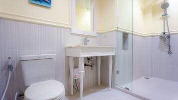A bathroom with a toilet, sink, and shower.