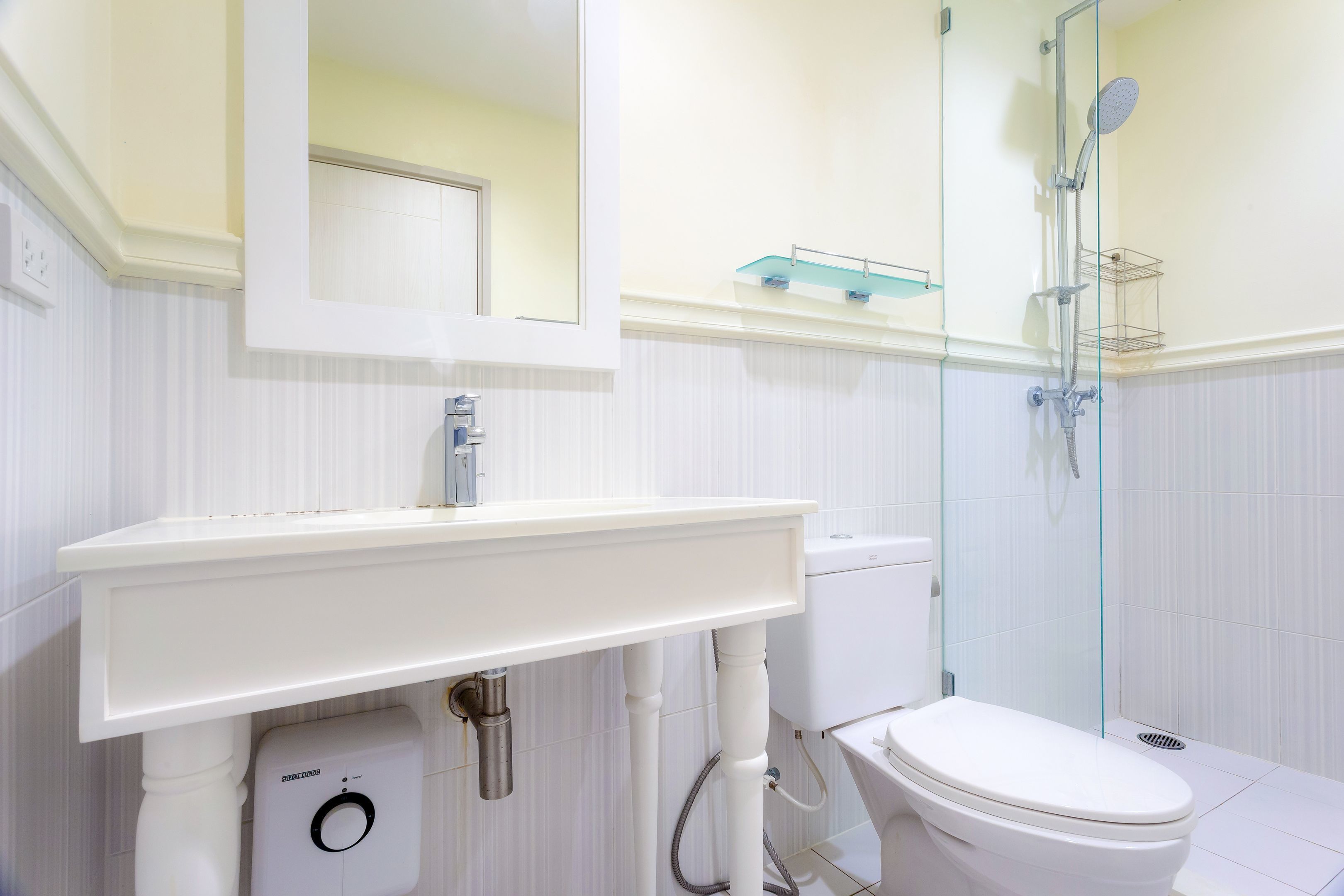 A modern bathroom with a white sink, toilet, and glass-enclosed shower.