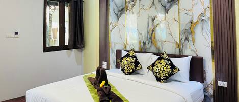 A hotel room with a bed, a window with curtains, a wall with a marble-like pattern, and a ceiling light fixture.