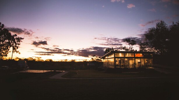 A modern building with large windows and a glass facade, surrounded by trees and a clear sky. - The Woolshed at Jondaryan - Campsite (Jondaryan)