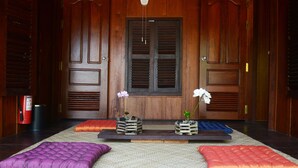 A room with a wooden door, a fire extinguisher, and two potted plants on a shelf. - Dracaena Resort (Prasat Sambour)
