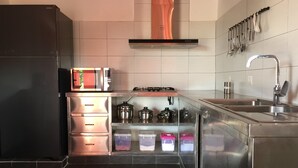 A modern kitchen with stainless steel appliances, a gas stove, and a built-in oven. - Dracaena Resort (Prasat Sambour)