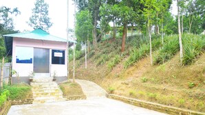 A reception area with a sign, a staircase leading up, and a pathway. - Green Palace Tea Resort (Kamalganj)