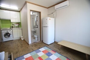 A compact kitchen with a washing machine, a refrigerator, and a bench. - Namu Guesthouse & Pension - Hostel (Yeosu)