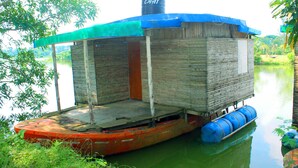 A floating house with a blue roof, a water tank, and a dock.