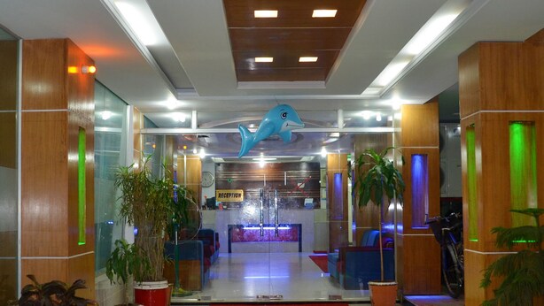 A hotel lobby with a reception desk, potted plants, and a blue dolphin sculpture on the ceiling. - Saint Martin Resort (Cox's Bazar)