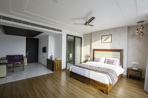 Un dormitorio moderno con una cama grande, un ventilador de techo y suelo de madera.