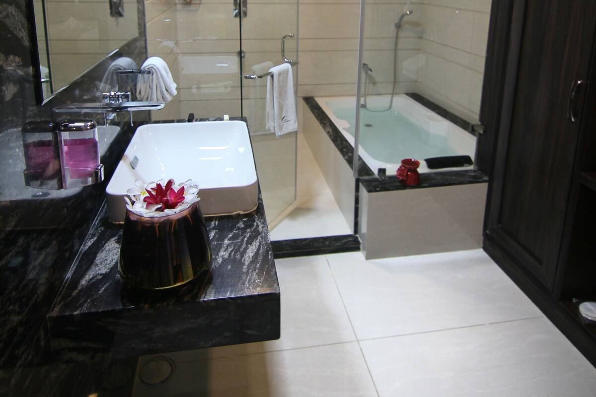pool view suite with bathtub | bathroom | deep-soaking bathtub, rainfall showerhead, free toiletries, hair dryer