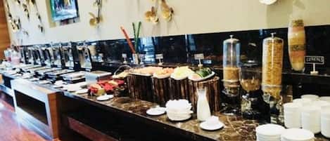 A buffet setup with various food items and condiments.