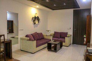 A modern living room with a sofa set, a coffee table, and a wall-mounted light fixture.
