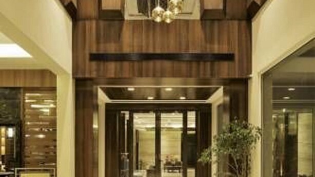 A modern hotel lobby with a central chandelier, a reception desk, and a large window. - Brahma Horizon Hotel & Spa – Pushkar (Pushkar)
