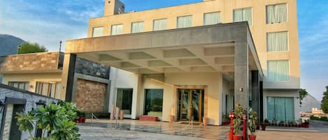 Un hotel moderno con techo plano, ventanas amplias y entrada cubierta.