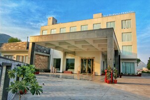 Un hotel moderno con techo plano, ventanas amplias y entrada cubierta.