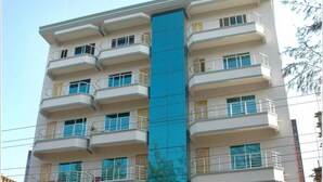 A multi-story building with balconies, a central blue vertical feature, and signage for Albatross Resort. - Albatross Resort (Cox's Bazar)