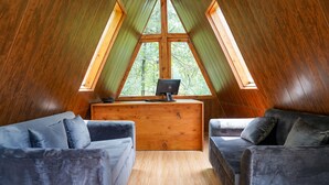 Acogedor dormitorio en el ático con un escritorio de madera y dos sofás cómodos.
